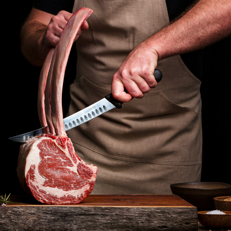 Persona cortando un trozo de carne de res